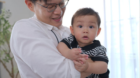 Father and son play together after dad comes home from workの写真素材