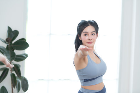 Asian young women doing yoga exercises during their holiday at homeの写真素材