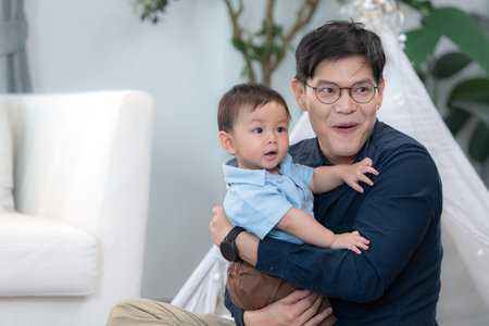 Father and son play together after dad comes home from workの写真素材