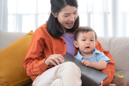 Mother and son play together after dad comes home from workの写真素材