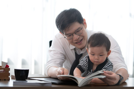 A business father and his duty to take care of his children while workingの写真素材