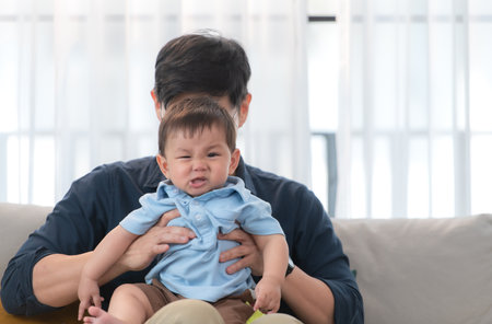 Father and son play together after dad comes home from workの写真素材