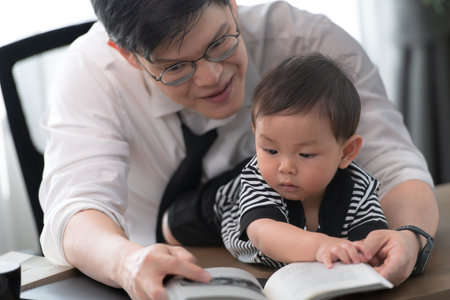 A business father and his duty to take care of his children while workingの写真素材