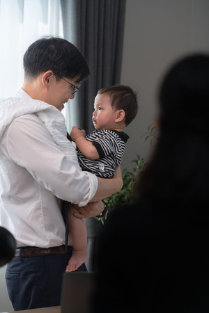 A business father assigns work to his secretary, while also taking care of his child while working