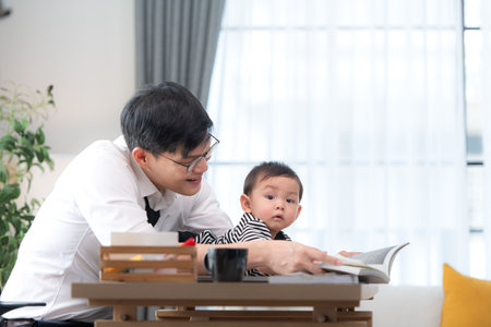 A business father and his duty to take care of his children while workingの写真素材