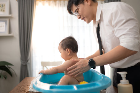 When dad gives the baby a bath, he enjoys itの写真素材