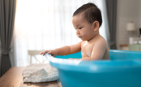 When parents gives the baby a bath, he enjoys itの写真素材