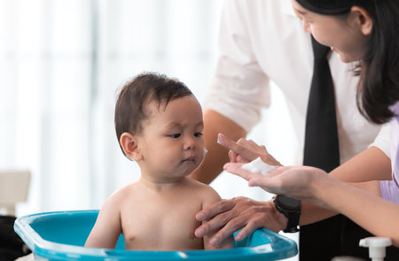Father and mother bathe their son after they come home from workの写真素材