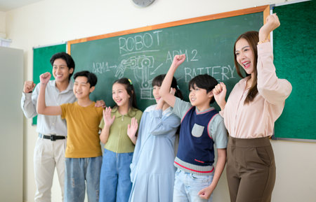 Portrait of a teacher and kids in a classroom where children have pleasure learningの写真素材