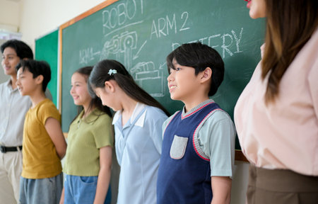 Portrait of a teacher and kids in a classroom where children have pleasure learningの写真素材