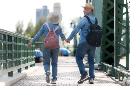 Elderly couples travel on the old iron bridge (Phra Phutthayotfa Bridge) in Bangkok, Thailandの写真素材