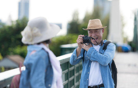 Elderly couples travel on the old iron bridge (Phra Phutthayotfa Bridge) in Bangkok, Thailandの写真素材