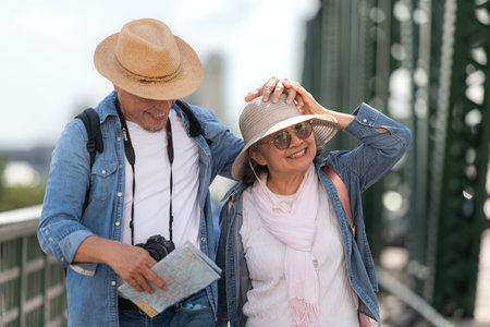 Elderly couples travel on the old iron bridge (Phra Phutthayotfa Bridge) in Bangkok, Thailandの写真素材