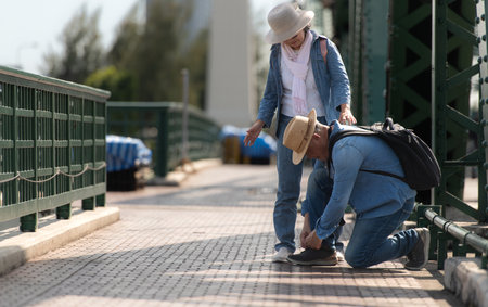 Elderly couples travel on the old iron bridge (Phra Phutthayotfa Bridge) in Bangkok, Thailandの写真素材