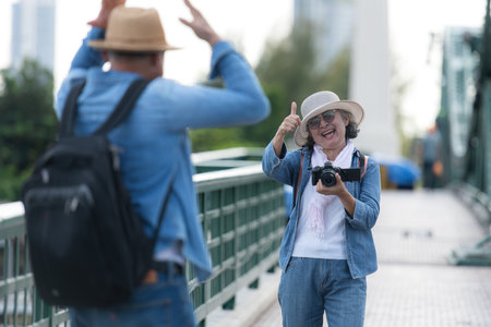 Elderly couples travel on the old iron bridge (Phra Phutthayotfa Bridge) in Bangkok, Thailandの写真素材