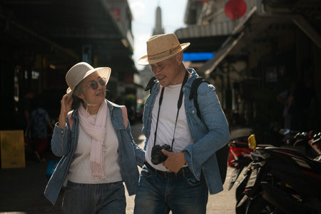 Elderly couples and their activities on the road at the end of the alley where there is a pagoda of Wat Arun, Thailandの写真素材