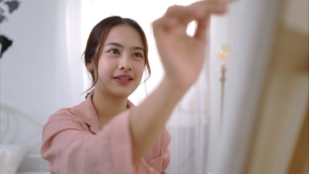 Asian young woman enjoying the happiness of paintingの写真素材