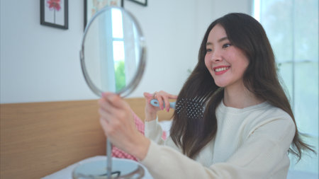 Asian young women conducting their weekly holiday routines from getting up, putting on cosmetics and relaxingの写真素材