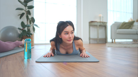 Asian young women doing yoga exercises during their holiday at homeの写真素材