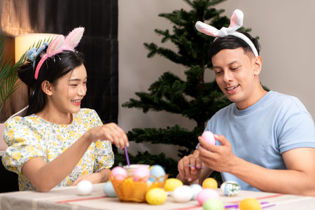 A young couple is designing and painting Easter eggs on Easter