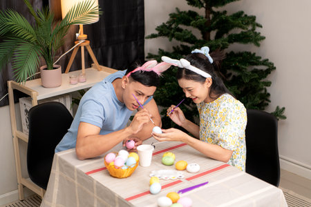 A young couple is designing and painting Easter eggs on Easter