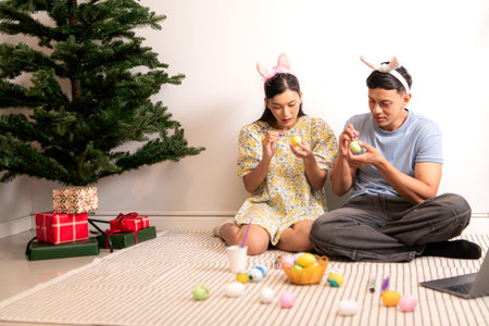 A young couple is designing and painting Easter eggs.