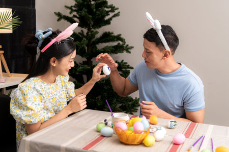A young couple is designing and painting Easter eggs on Easter