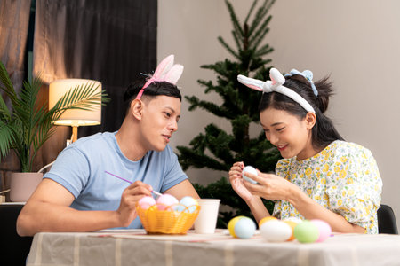 A young couple is designing and painting Easter eggs on Easter