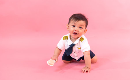 Portrait of child in pilot clothes in pink background