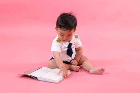 Portrait of child in pilot clothes in pink background