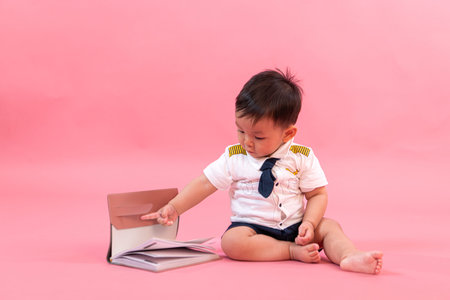 Portrait of child in pilot clothes in pink background