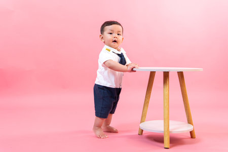 Portrait of child in pilot clothes in pink background