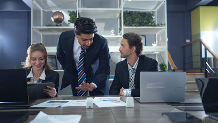 In the conference room, a group of businesspeople are discussing the follow-up meeting and the...