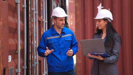 Container manufacturing manager and businesswomen survey the area to plan the storage and moving of...