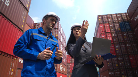 Container manufacturing manager and businesswomen survey the area to plan the storage and moving of...