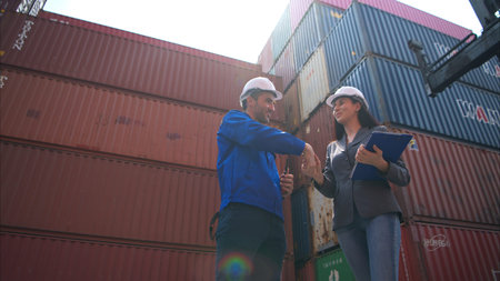 Container manufacturing manager and businesswomen survey the area to plan the storage and moving of...