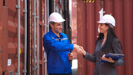 Container manufacturing manager and businesswomen survey the area to plan the storage and moving of goods in and out of the container storage areaの写真素材