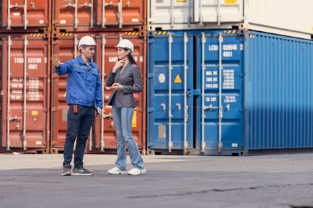 Container manufacturing manager and businesswomen survey the area to plan the storage and moving of...