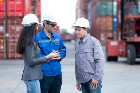 Container manufacturing manager and businesswomen survey the area to plan the storage and moving of goods in and out of the container storage areaの写真素材