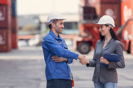 Container manufacturing manager and businesswomen survey the area to plan the storage and moving of...