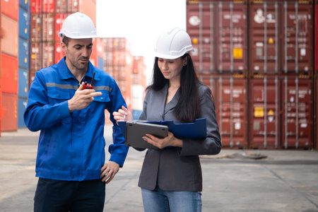 Container manufacturing manager and businesswomen survey the area to plan the storage and moving of goods in and out of the container storage areaの写真素材
