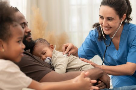 A doctor uses a stethoscope to check on the health of a sleeping baby as he rests in his father's armsの写真素材