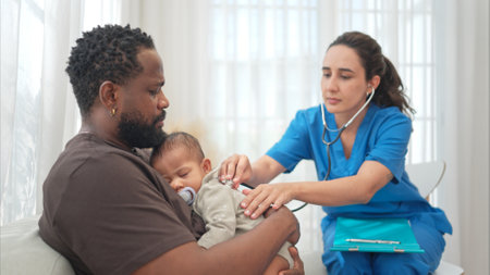 A doctor uses a stethoscope to check on the health of a little boy as he sleeps in his father's armsの写真素材