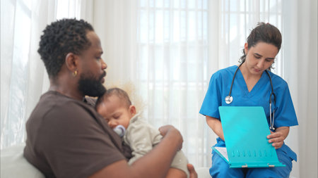 A doctor uses a stethoscope to check on the health of a baby as he sleeps in his father's arms