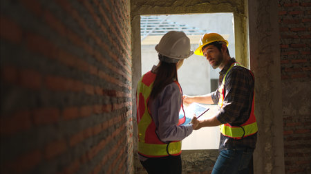 Architects and engineers work together to assess the residential home construction site's progress