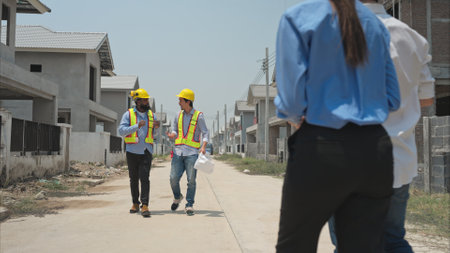 Group of architects and engineers work together to assess the residential home construction site's progressの写真素材