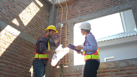 Architects and engineers work together to assess the residential home construction site's progress