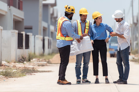 Group of architects and engineers work together to assess the residential home construction site's...