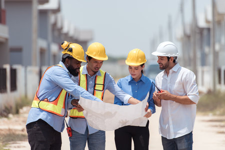 Group of architects and engineers work together to assess the residential home construction site's progressの写真素材