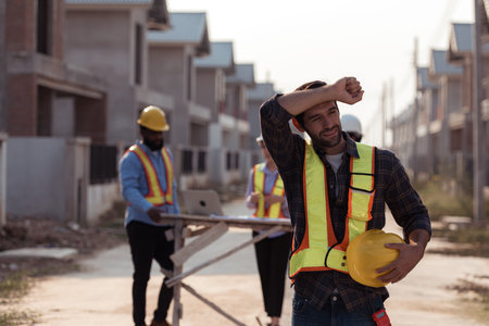 Portrait of engineers work together to assess the residential home construction site's progress